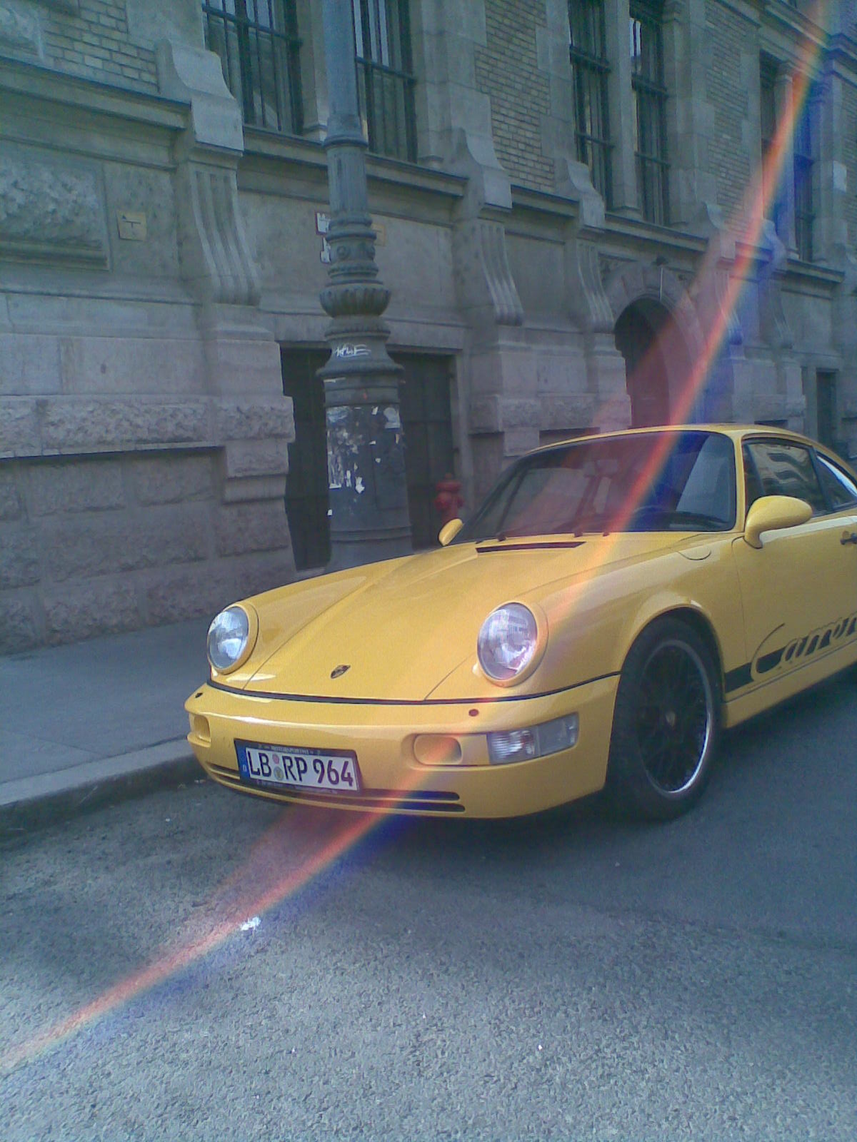 Yellow Porsche on a gray city street